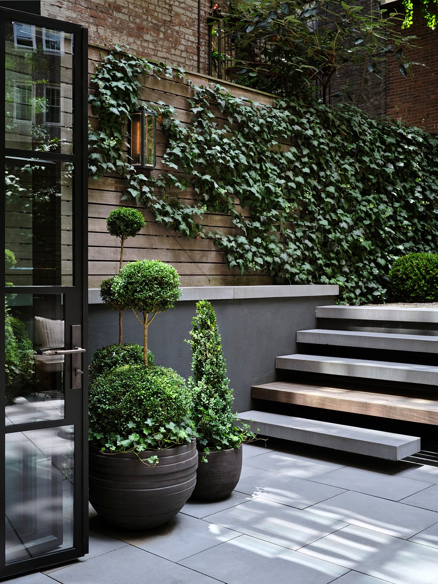 The rear gardens integrated stair and planters by an open glass door